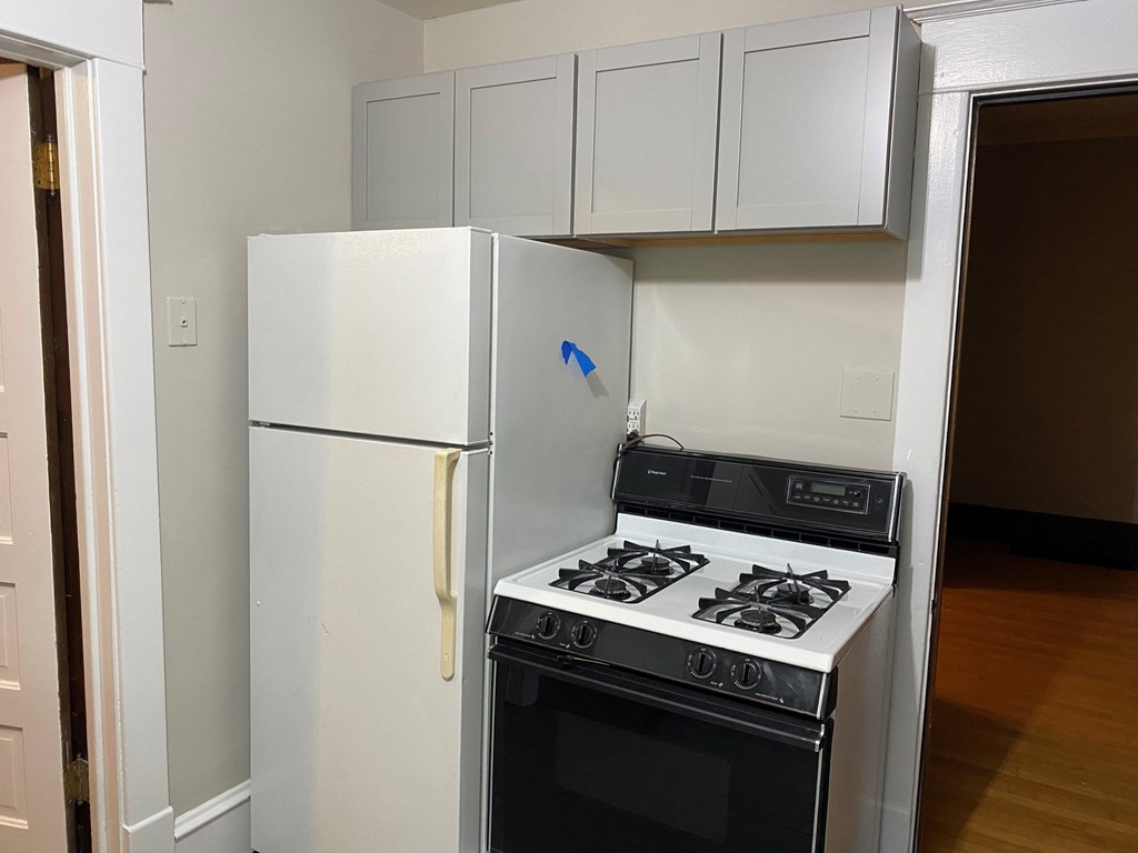 a small kitchen with a stove and a refrigerator