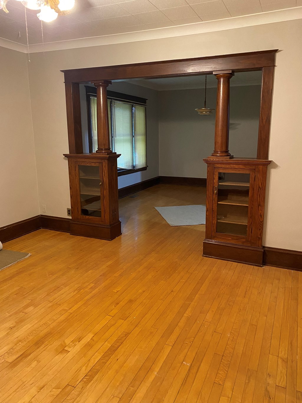 an empty living room with wooden floors and furniture