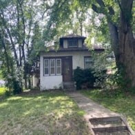 a small house in the woods with a path in front of it