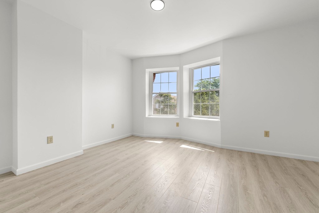 an empty living room with white walls and wood floors