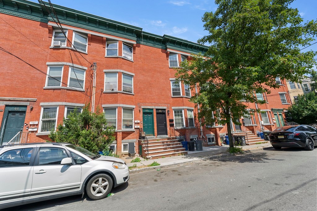 a red brick building with a white car parked in front of it