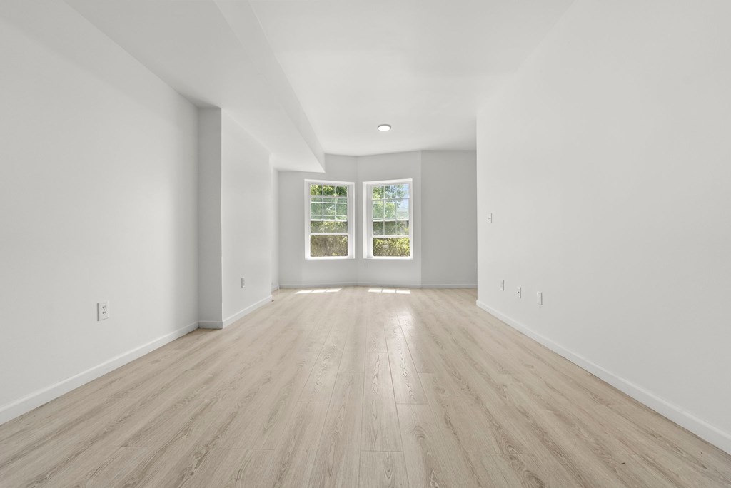 a living room with white walls and wood floors