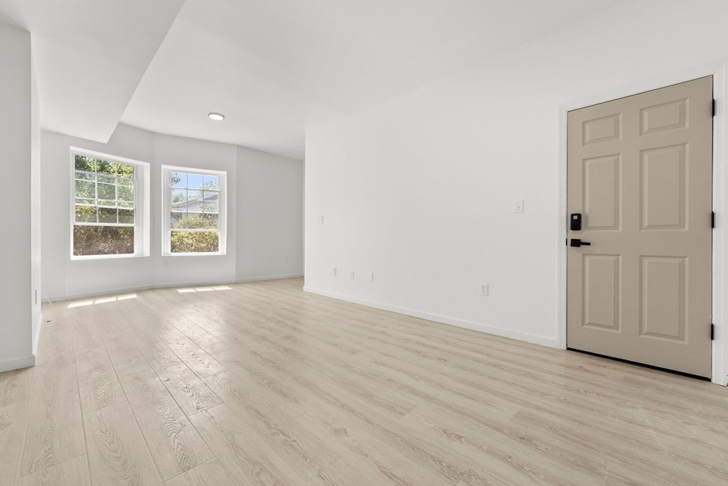 an empty living room with white walls and a white door