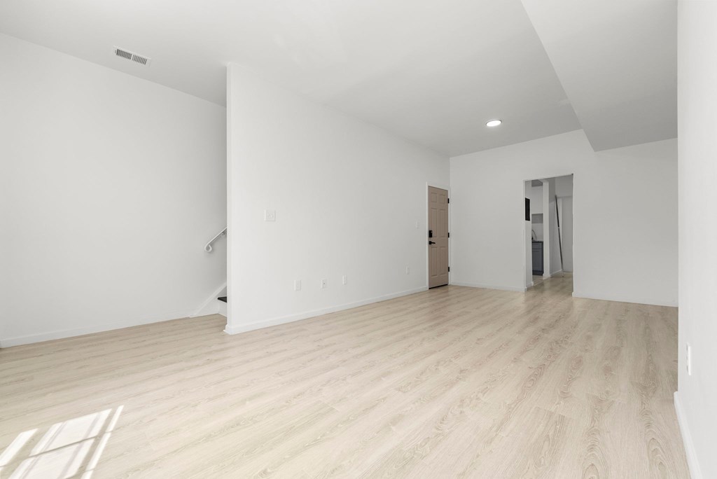a living room with white walls and a wooden floor