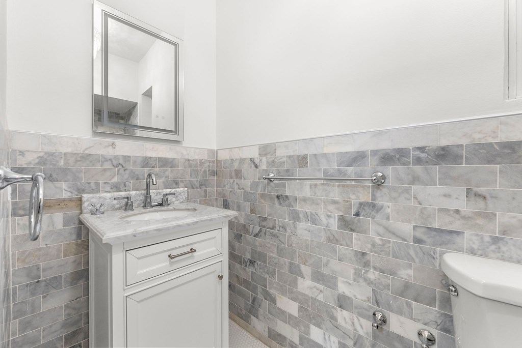 a white bathroom with a sink and a mirror