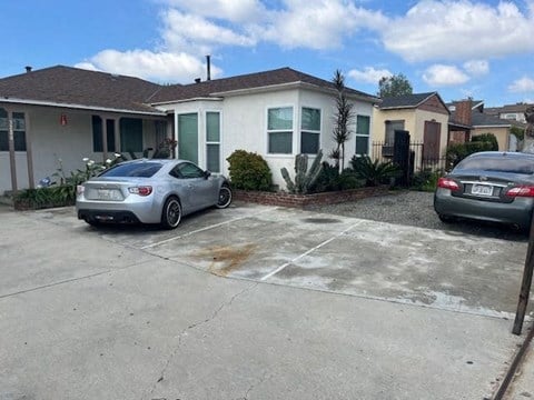 two cars parked in a driveway in front of a house