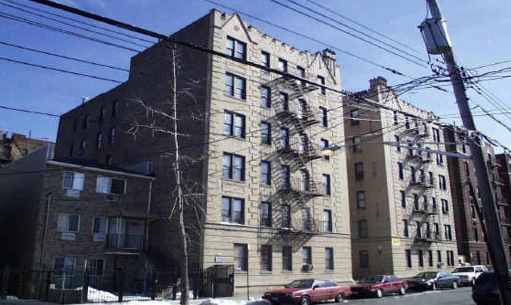 a tall building with cars parked in front of it