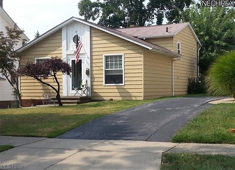 a yellow house with an flag on the door