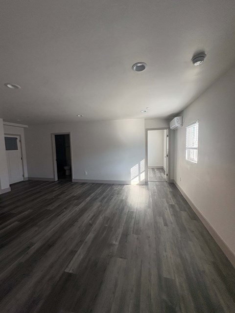 A room with wooden flooring and white walls.