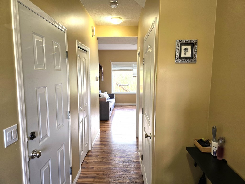 a hallway with white doors and a living room with a couch