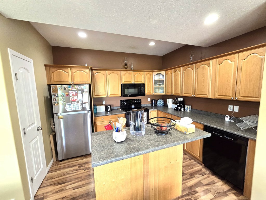a kitchen with wooden cabinets and a granite counter top