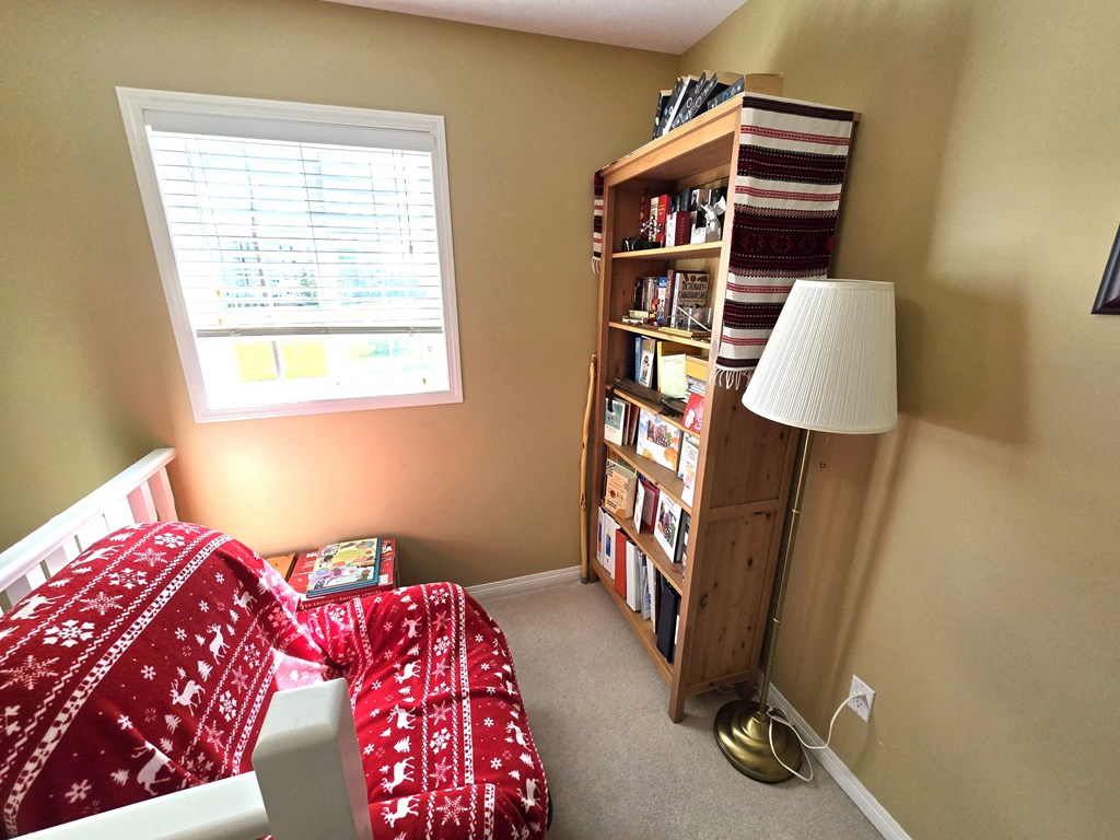 a bedroom with a bed and a bookshelf with books