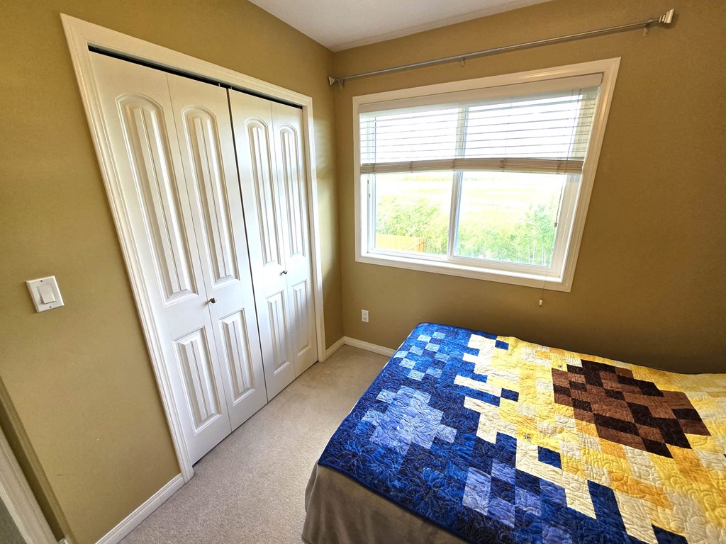a bedroom with a bed and a window and a closet