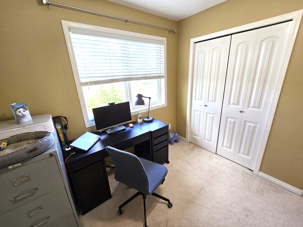 a home office with a desk and a window