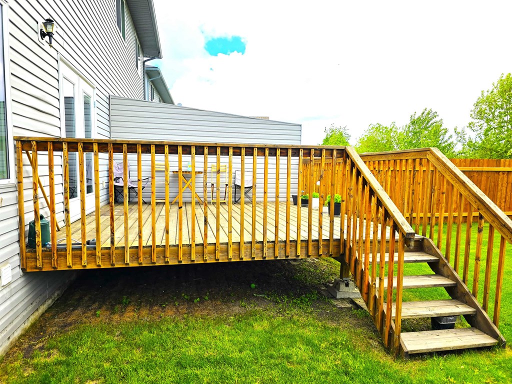 a wooden deck in the backyard of a house