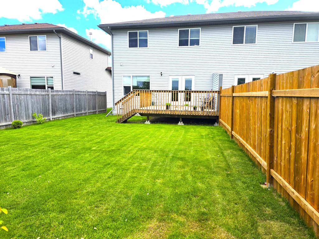 a backyard with a wooden fence and a house