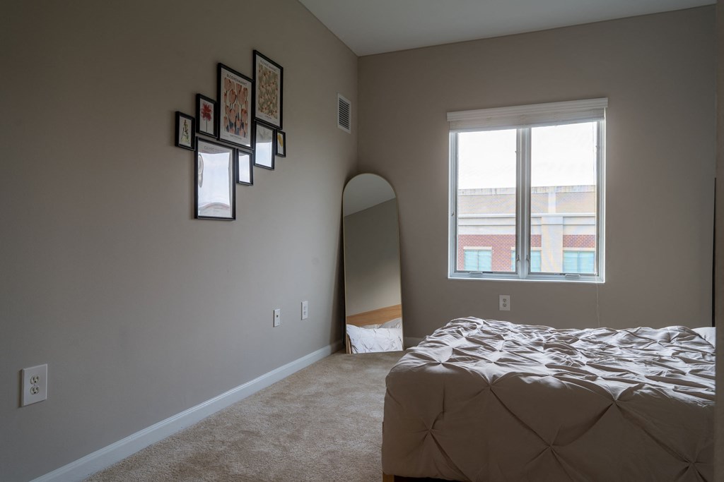 an empty bedroom with a bed and a window