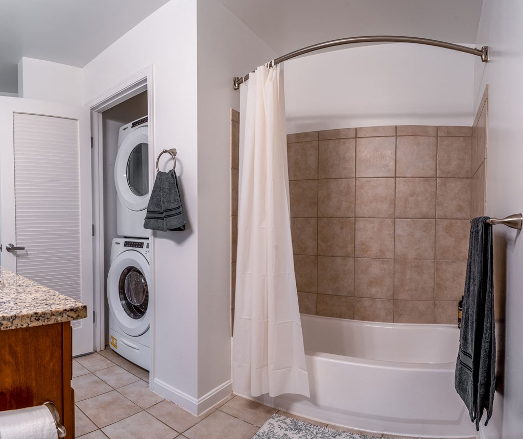 a bathroom with a tub and a washing machine in it