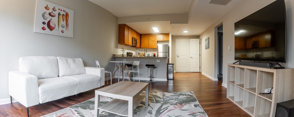 a living room and kitchen with a couch and a table