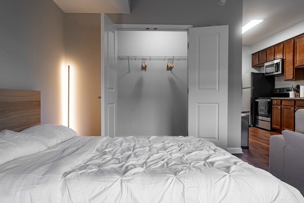 a bedroom with a bed and a refrigerator