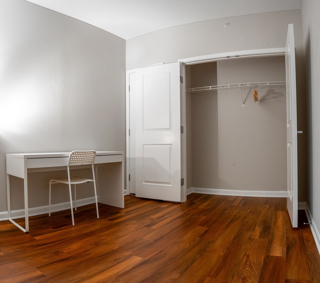 an empty room with a desk and an open closet