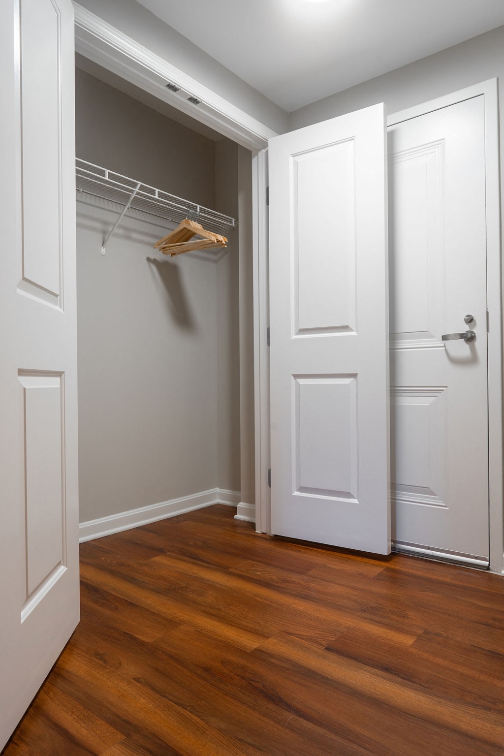 a closet with a white closet door and a wood floor