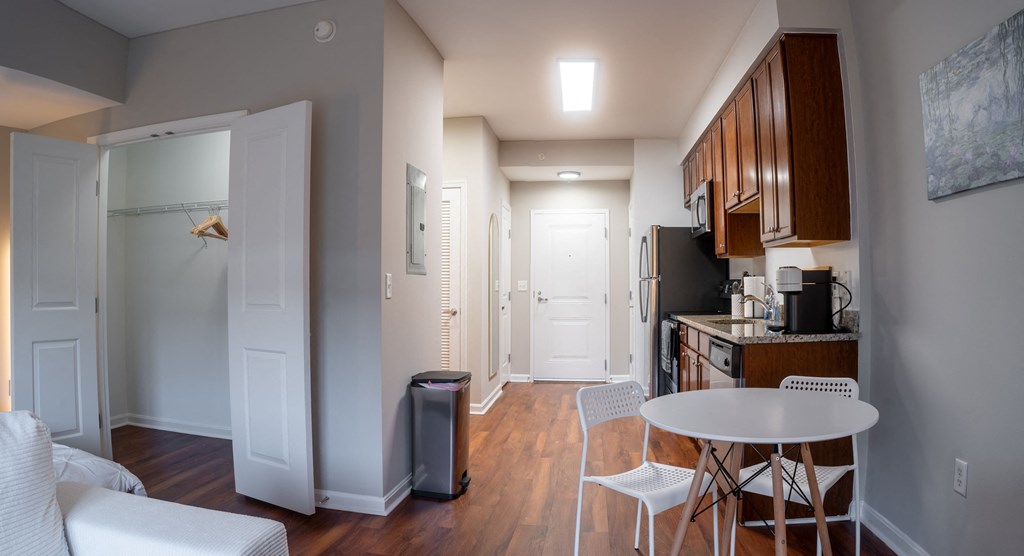 a kitchen and living room with a small white table and chairs