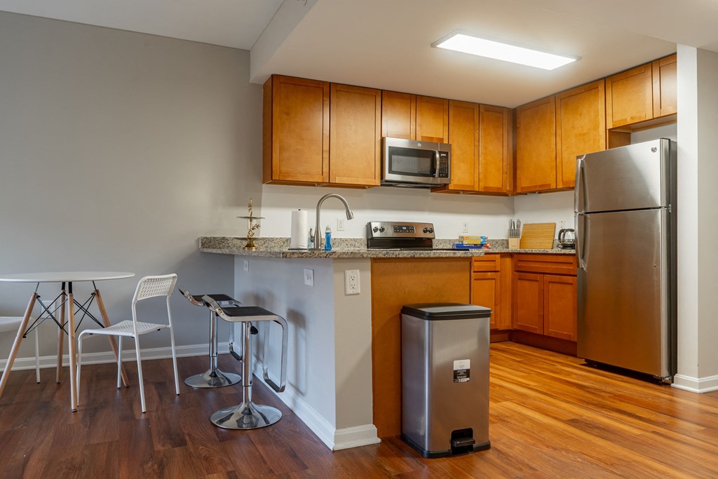 a kitchen with stainless steel appliances and a bar with stools