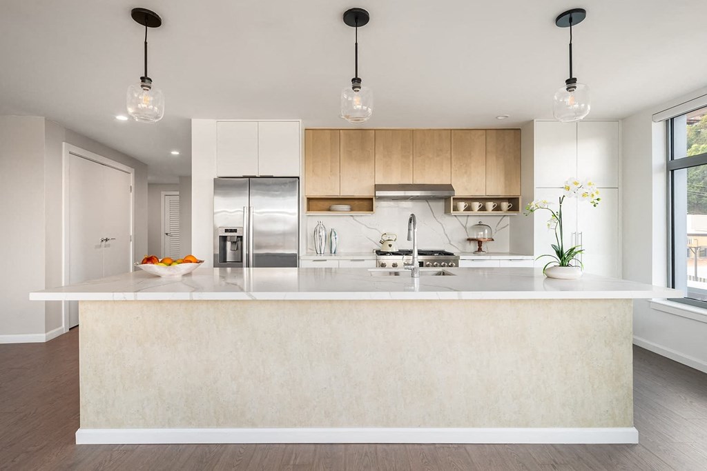 a white kitchen with a large island and a stainless steel