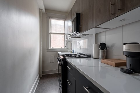 a kitchen with a counter top and a stove and a window