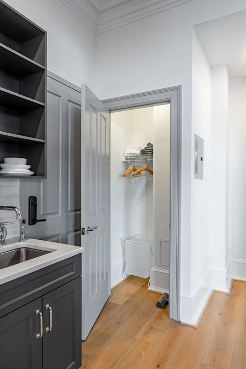 a small kitchen with a sink and a door to a closet