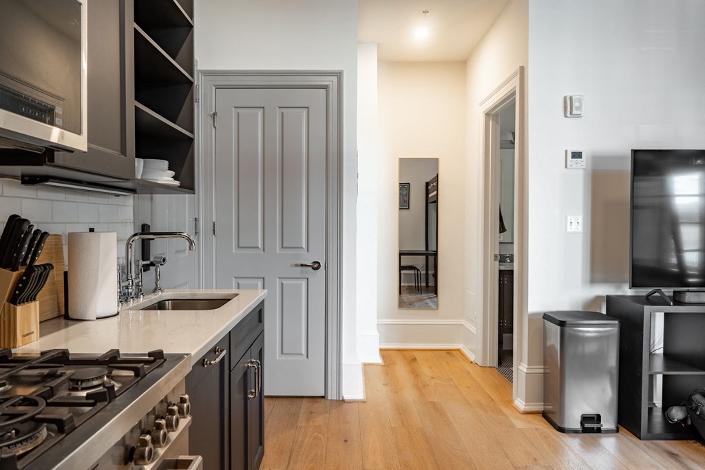 a kitchen with a sink and a stove and a door to a hallway