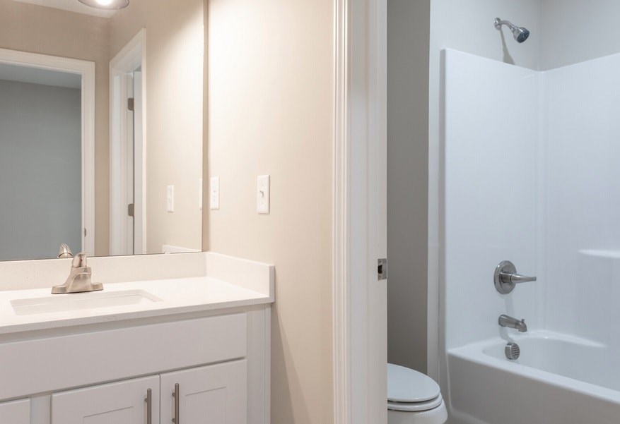 A white bathroom with a toilet, sink, and bathtub.