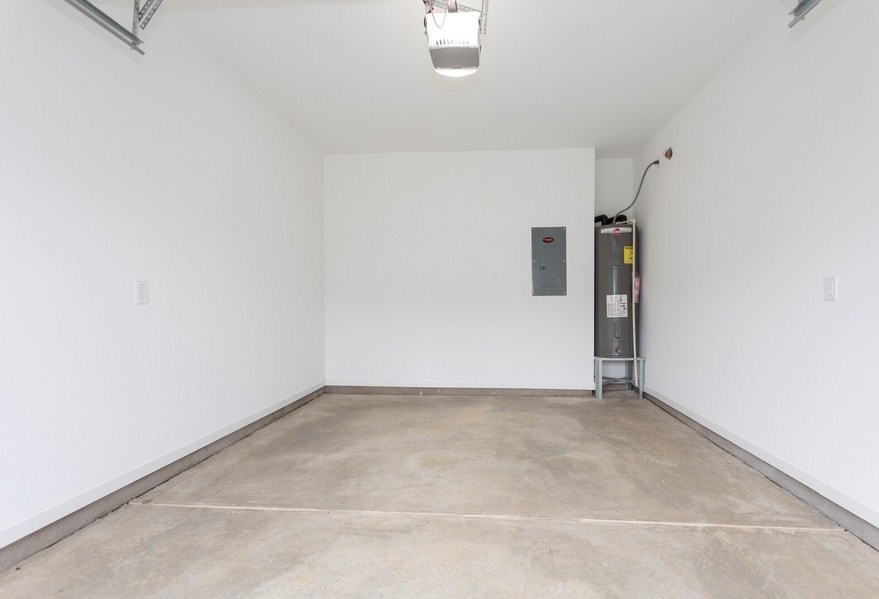 A large empty room with a concrete floor and white walls.