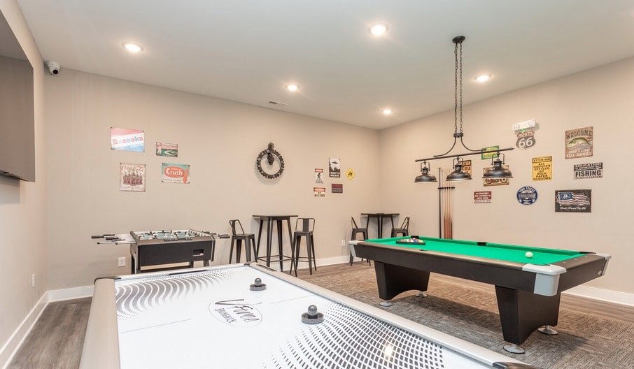 A room with a pool table and air hockey table.