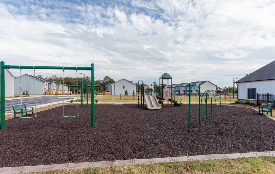 A playground with a swing set and a slide.