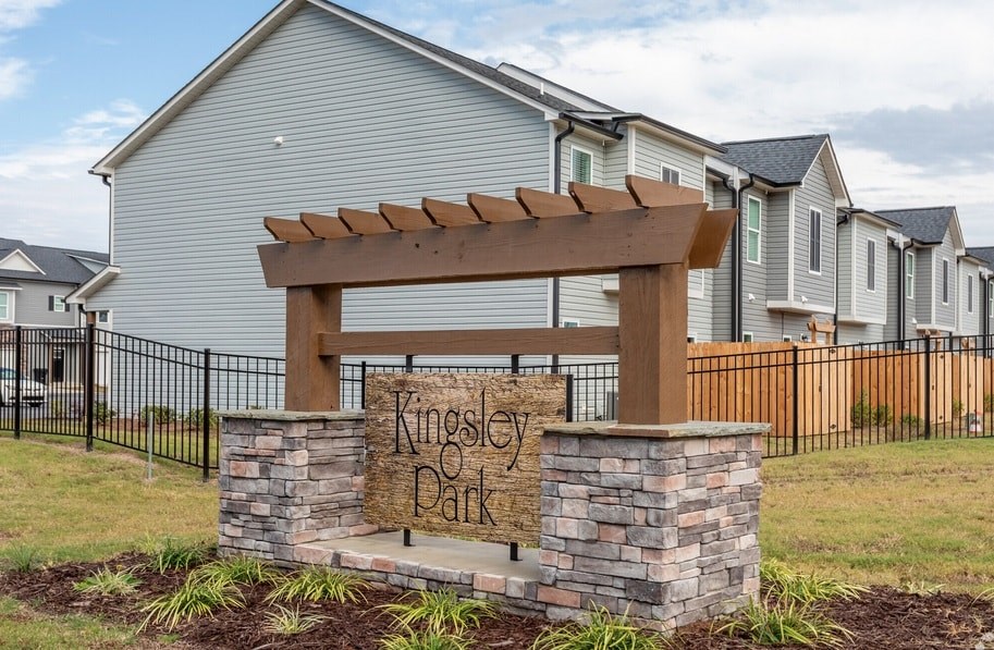 A sign that says Kingsley Park in front of some houses.