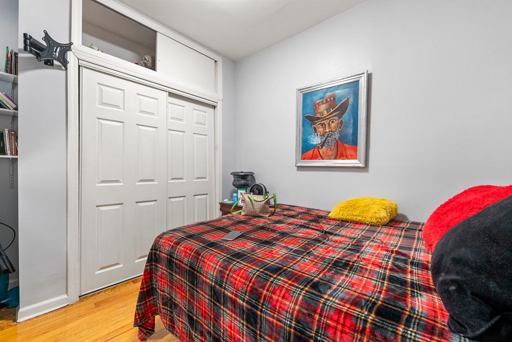 a bedroom with a bed with a tartan bedspread and a closet