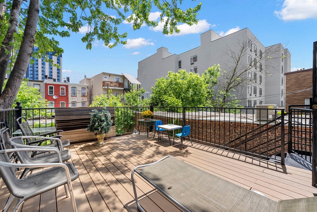 a patio with a table and chairs and a fence