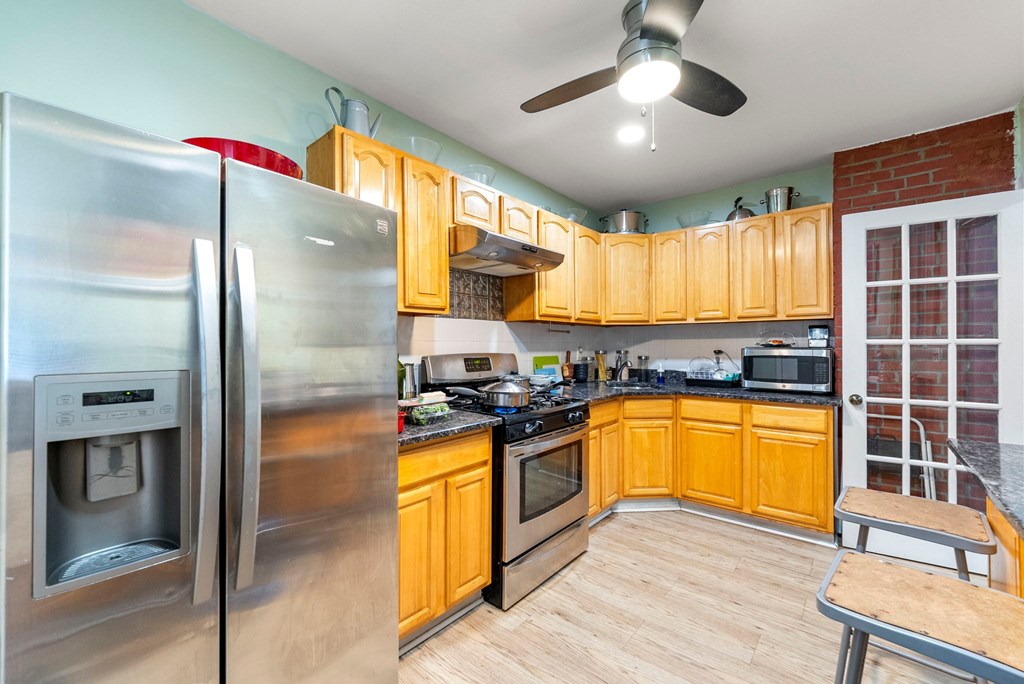 a kitchen with wooden cabinets and stainless steel appliances