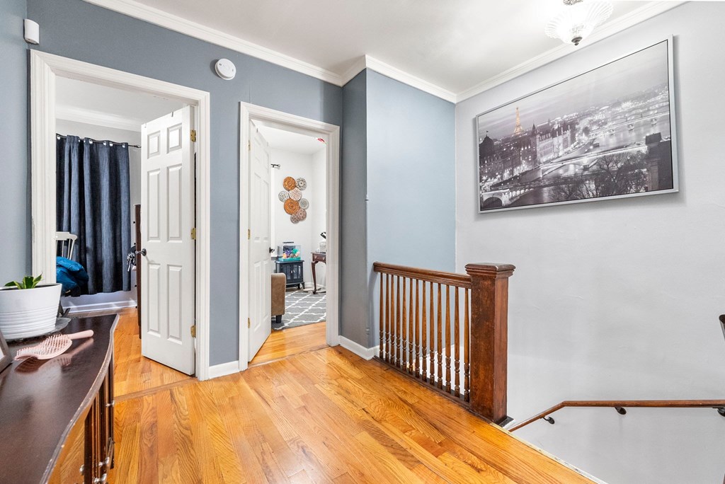 a living room with blue walls and a landing with a wooden railing and a door