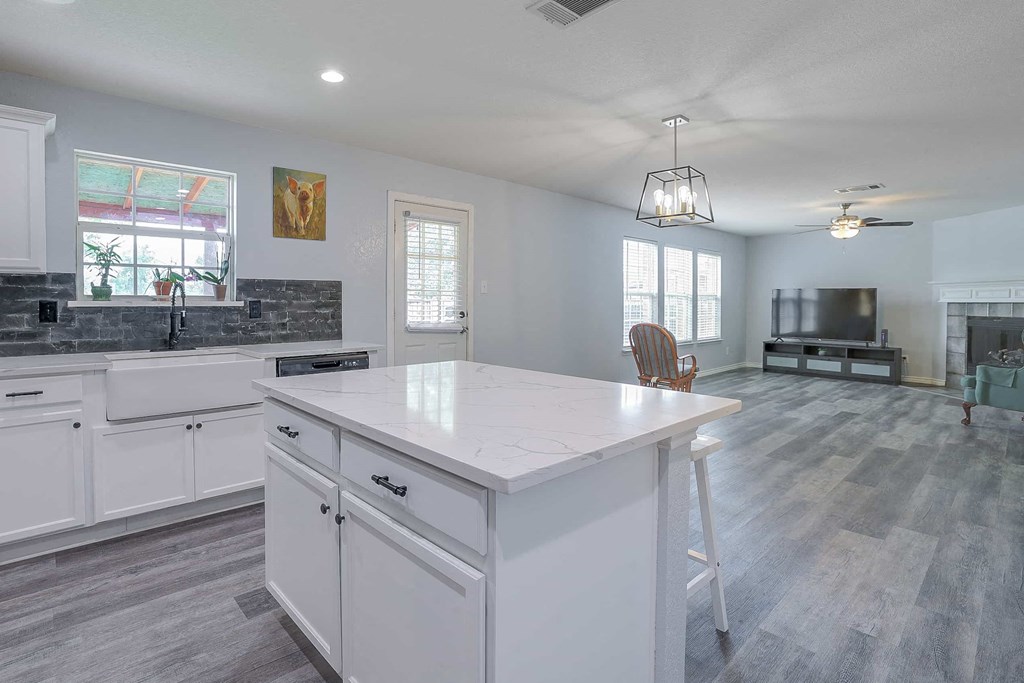 a white kitchen with a large island in the middle