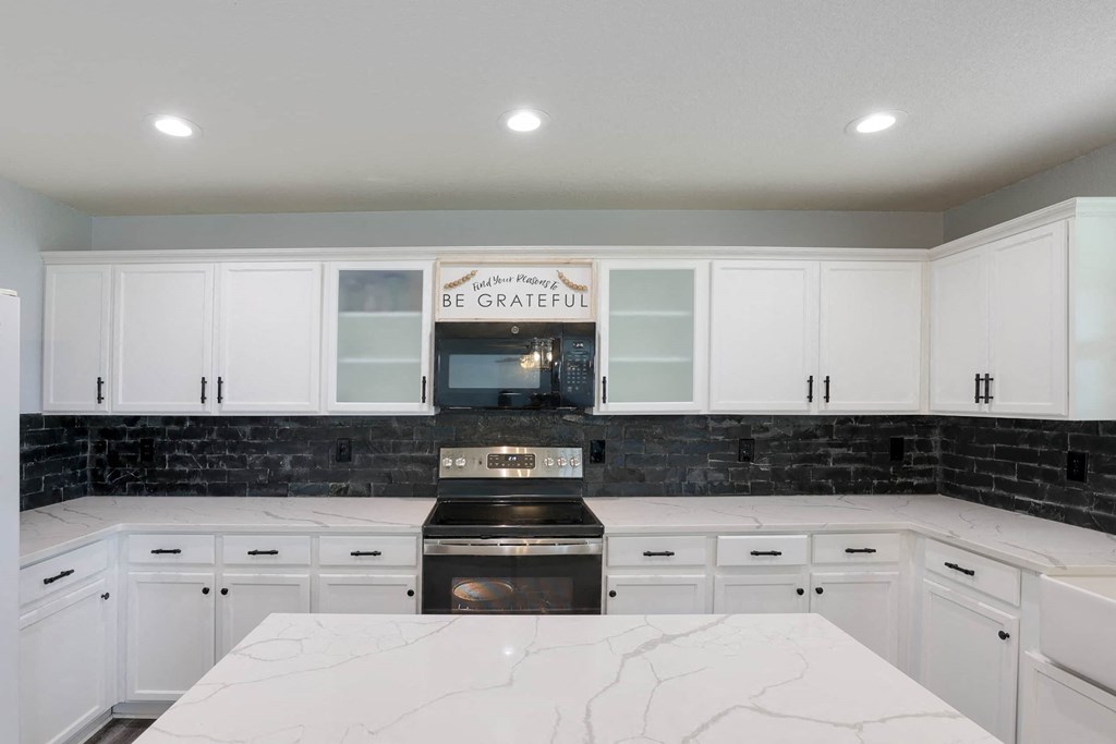 a kitchen with white cabinets and a stove