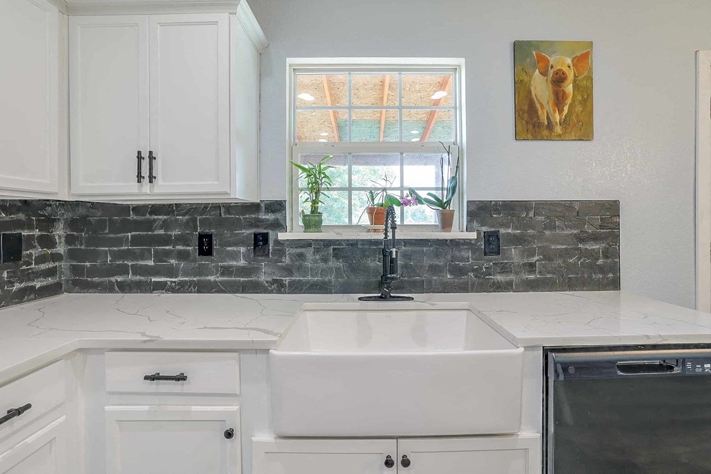 a white kitchen with a sink and a window