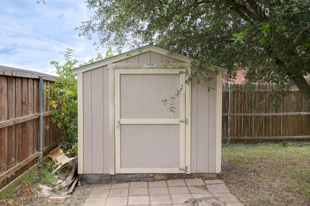 a small shed in a backyard next to a tree