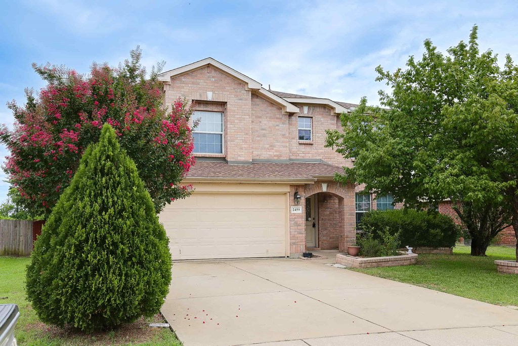 a brick house with a garage and a driveway