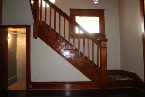 a stairway in a house with a wooden railing and a window