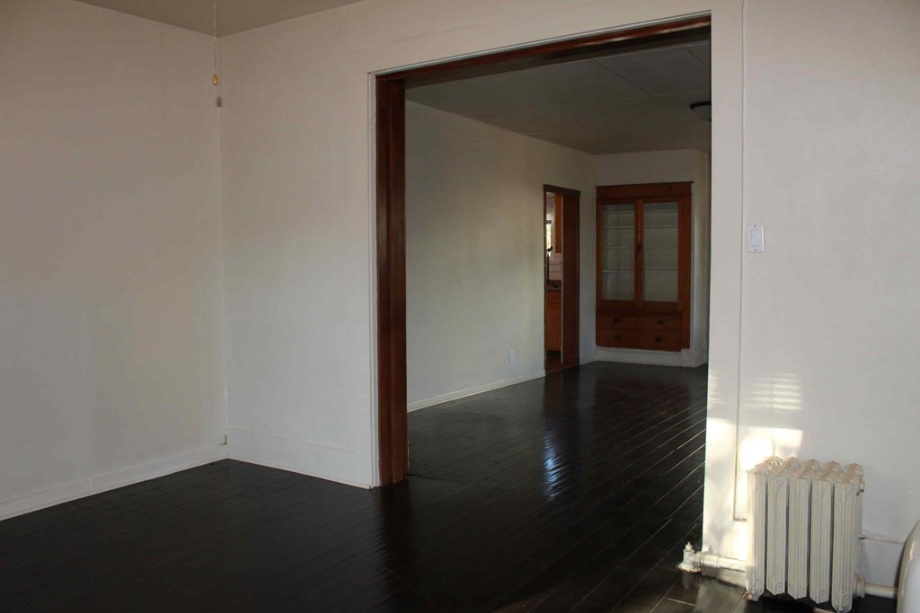 a living room with white walls and a wood floor