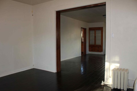 a living room with white walls and a wood floor