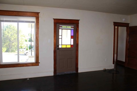 an empty room with a door and a window